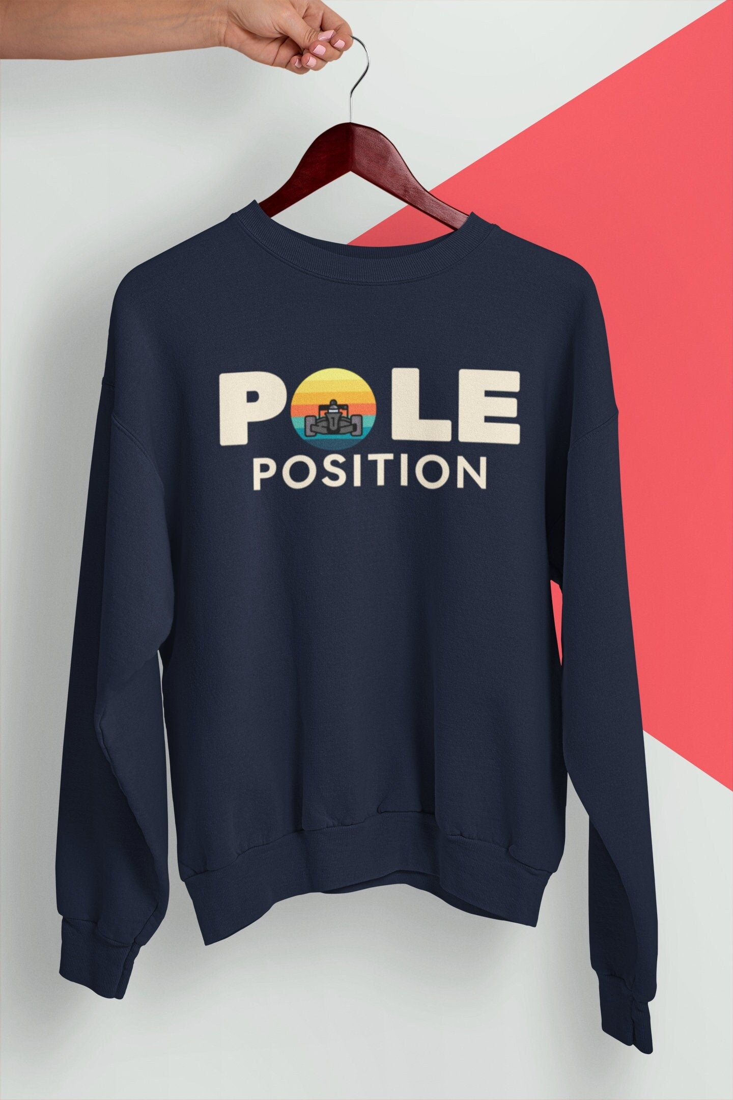 A navy blue sweatshirt with the text &#39;POLE POSITION&#39; in white text. A retro-style racing f1 car icon is above the text.