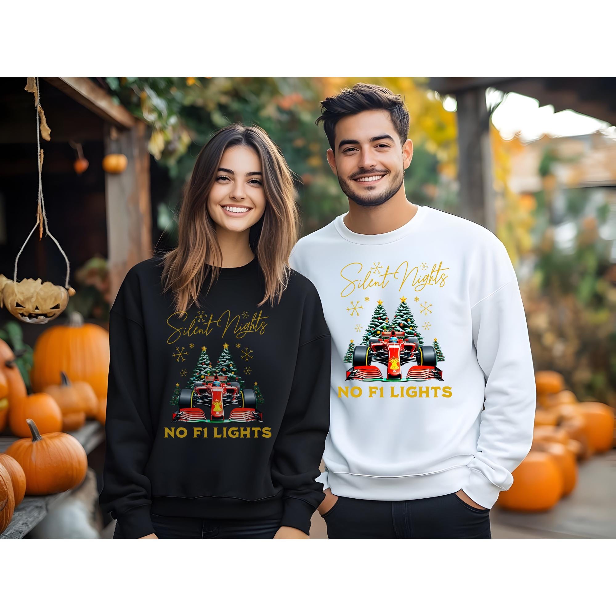 Matching Christmas sweatshirts with a Formula 1 racing car design.  The black sweatshirt and the white sweatshirt feature the text &#39;Silent Nights, NO F1 Lights&#39; in gold lettering, along with a small Christmas tree and a Formula 1 car graphic. The sweatshirts are shown on models against a fall-themed background.