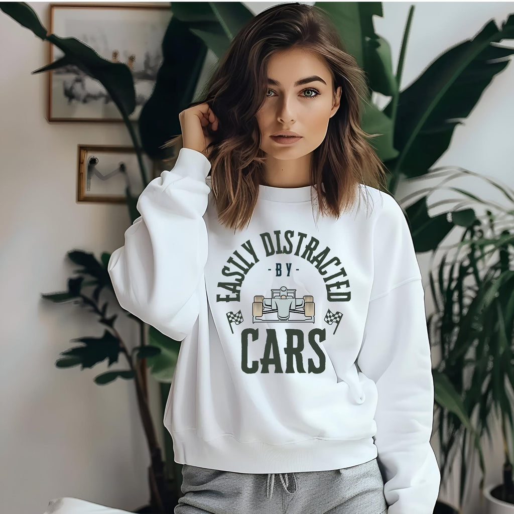 White sweatshirt with a green graphic that reads &#39;Easily Distracted - By - Cars&#39; with a cartoon car in the middle of the text.