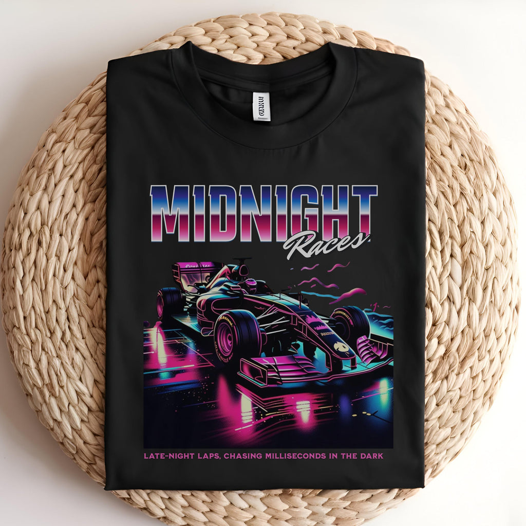 May include: A black t-shirt with a graphic of a purple and blue race car on a neon pink and blue track. The text &#39;MIDNIGHT Races&#39; is above the car in a pink, purple, and blue gradient. The text &#39;LATE-NIGHT LAPS, CHASING MILLISECONDS IN THE DARK&#39; is below the car in white text.